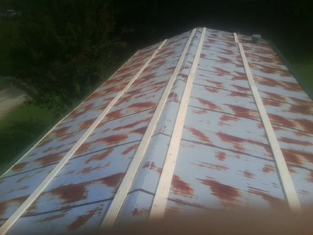 Rusted metal roof panels with new wood purlins before replacement — Storm Damage Roof Repair in East Northport by Roofing Brothers