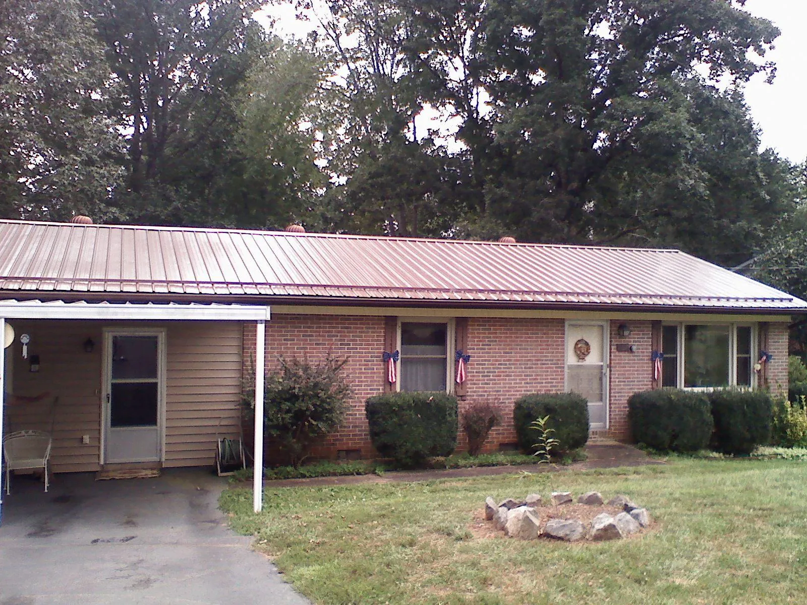 Bronze metal roof and carport on a brick ranch home — Roof Repair work by our crew in East Northport